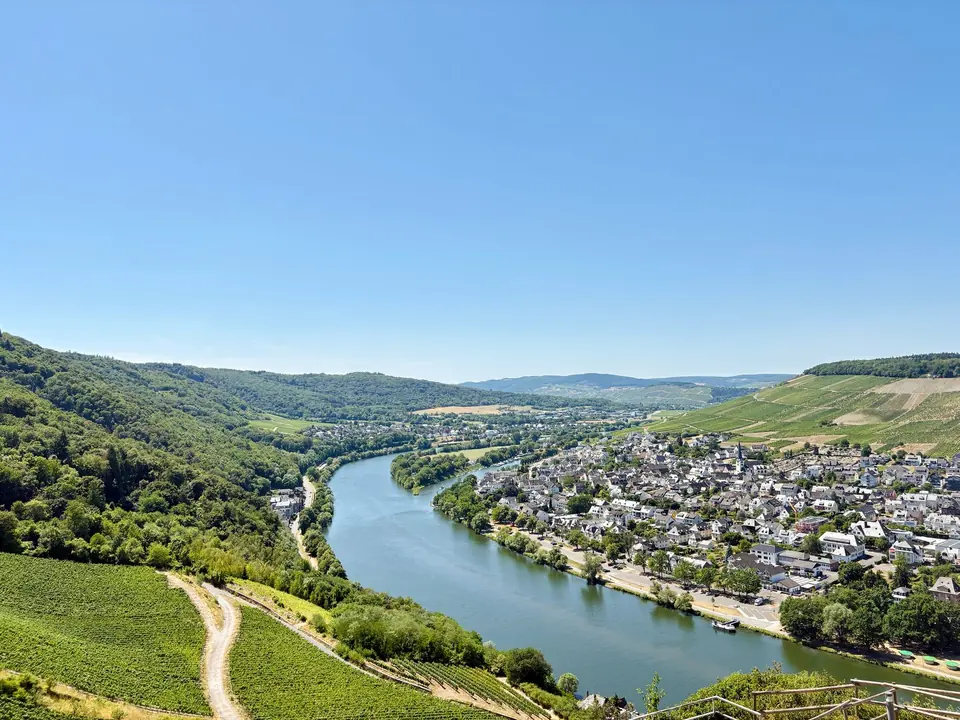 Eindrucksvolle Luftaufnahme von Bernkastel-Kues, Deutschland, mit der Mosel und Weinbergen im Sommer.